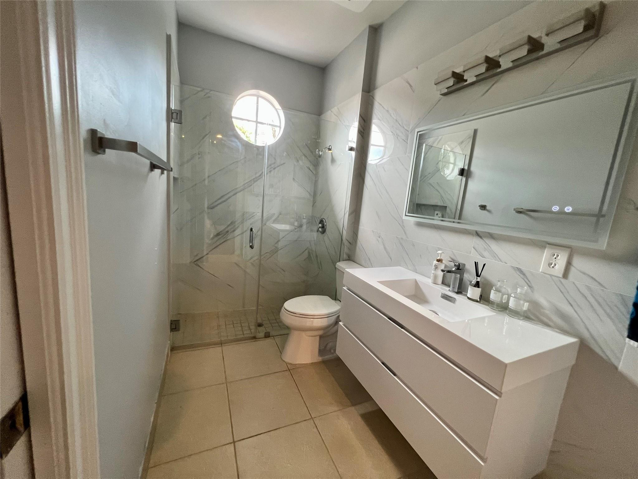 5201 Southwest 173rd Avenue Miramar, FL 33029 - Photo 34 of 42 a bathroom with a toilet a sink a mirror and a shower