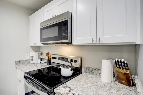 a kitchen with a stove a microwave and cabinets