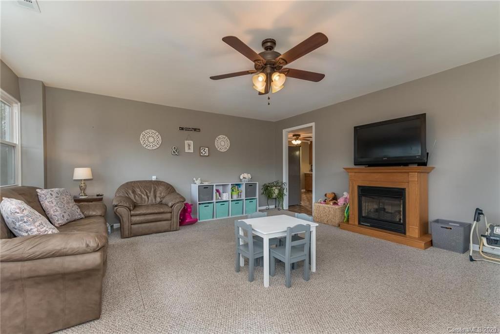 49 Smith Road Columbus, NC 28722 - Photo 14 of 32 a living room with furniture a fireplace and a flat screen tv