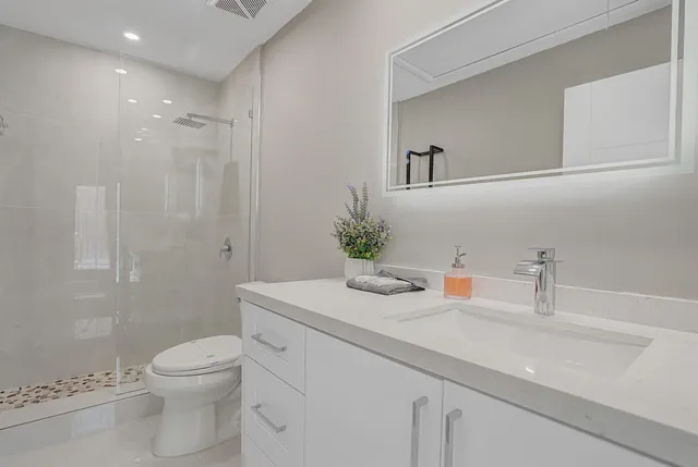 a bathroom with a sink a toilet and shower