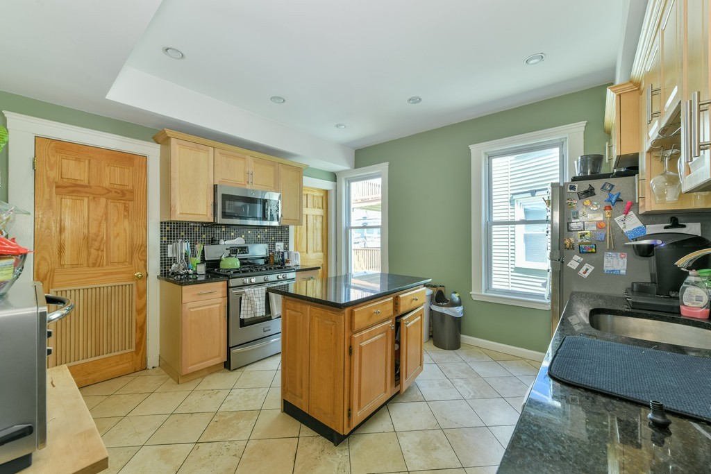 17-19 Pleasant Street Boston, MA 02125 - Photo 4 of 16 a kitchen with stainless steel appliances granite countertop a refrigerator and a stove top oven