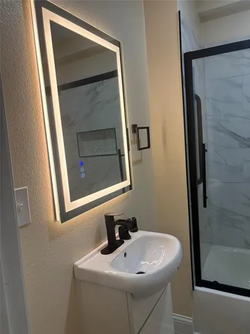 a bathroom with a sink and mirror with toilet