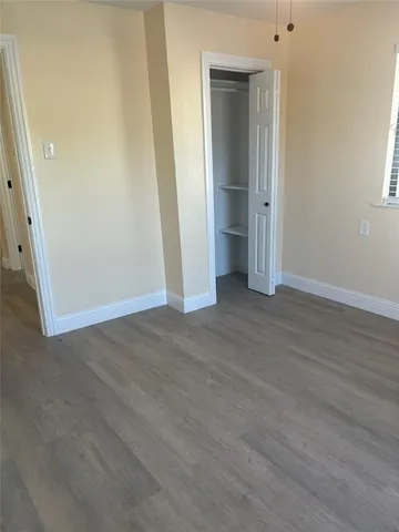 an empty room with wooden floor and closet