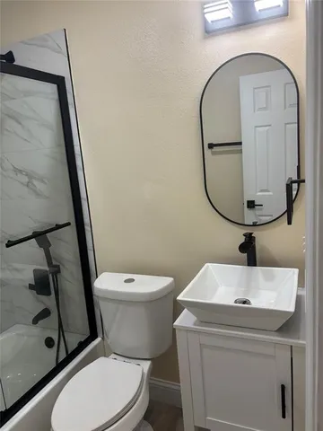 a white toilet sitting next to a bathroom sink