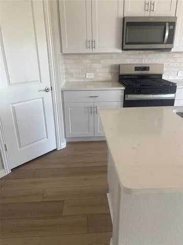 a kitchen with a microwave and a white cabinets