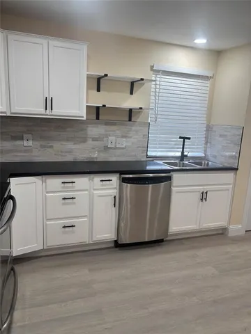 a kitchen with stainless steel appliances granite countertop a sink and a stove
