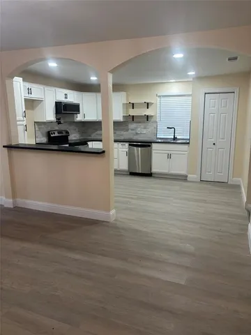 a large kitchen with stainless steel appliances granite countertop a stove and a refrigerator