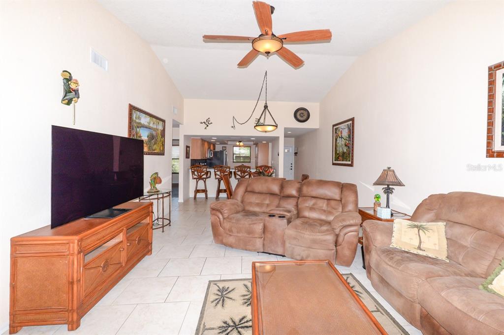 335 Coldeway Drive, Unit F21 Punta Gorda, FL 33950 - Photo 12 of 45 a living room with furniture a chandelier and a flat screen tv