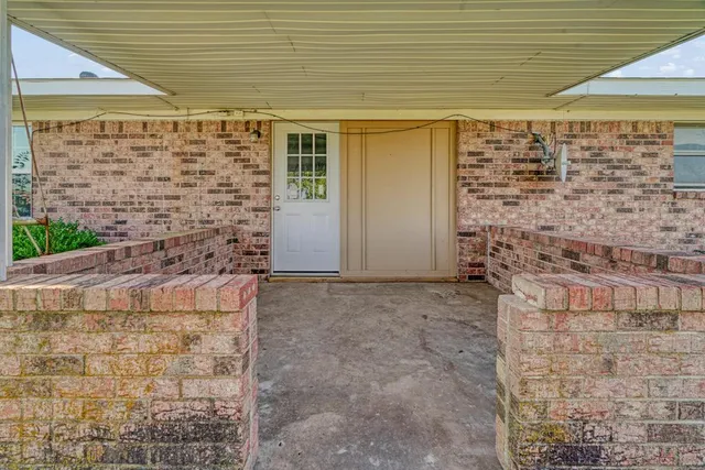 a view of front door and brick wall