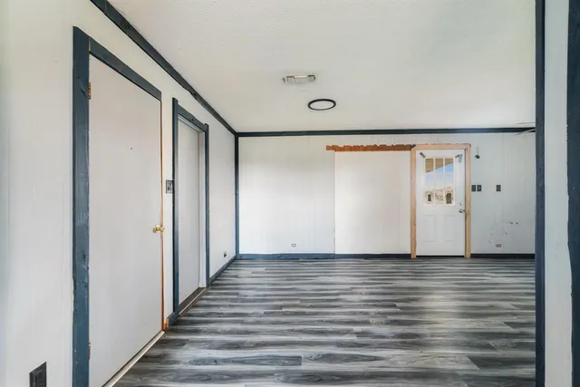 a view of a hallway with wooden floor and staircase