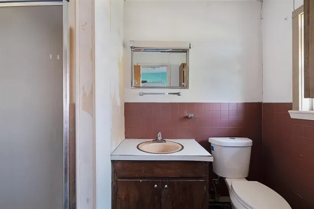 a bathroom with a toilet a sink and mirror