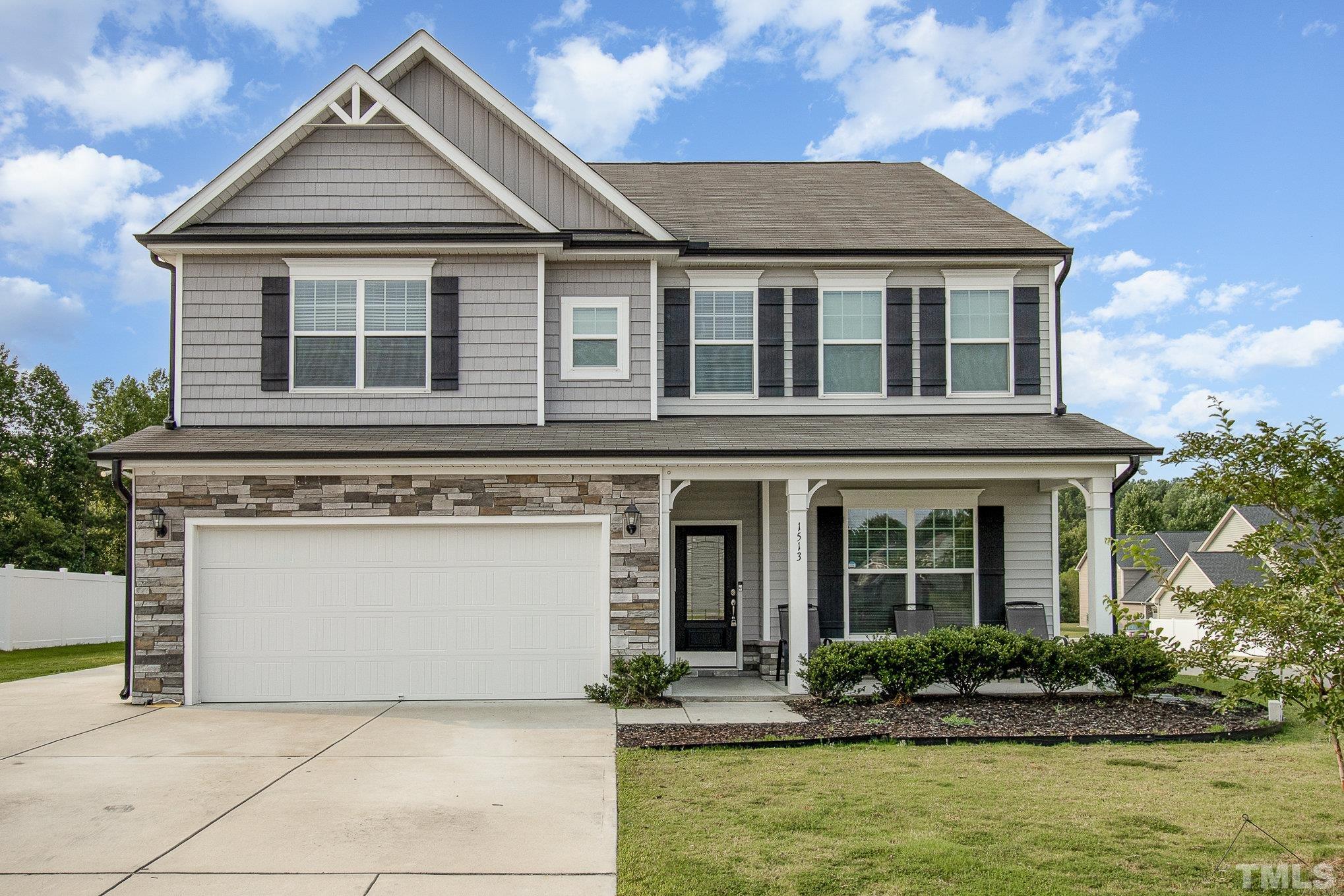a front view of a house with a yard and potted plants