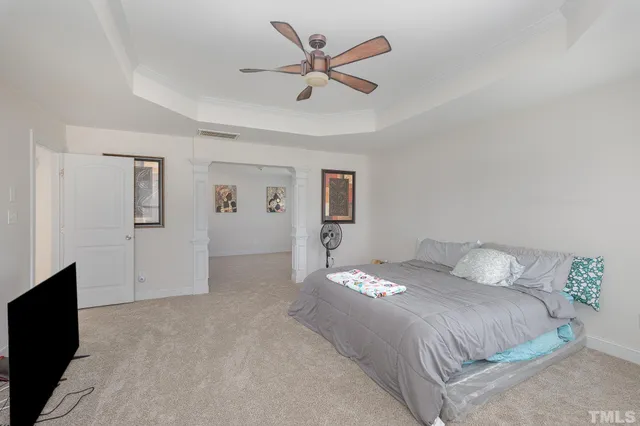a bedroom with a large bed and a ceiling fan
