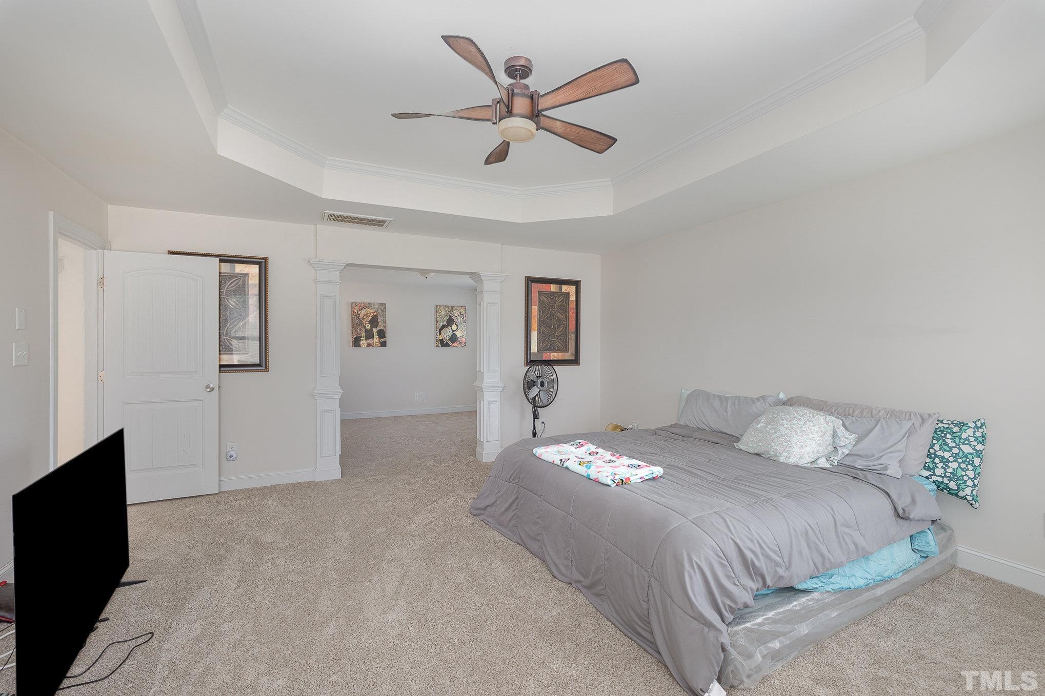 1513 Slate Ridge Road Knightdale, NC 27545 - Photo 17 of 36 a bedroom with a large bed and a ceiling fan