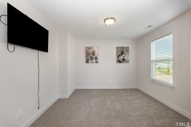 a view of room with window and a flat screen tv