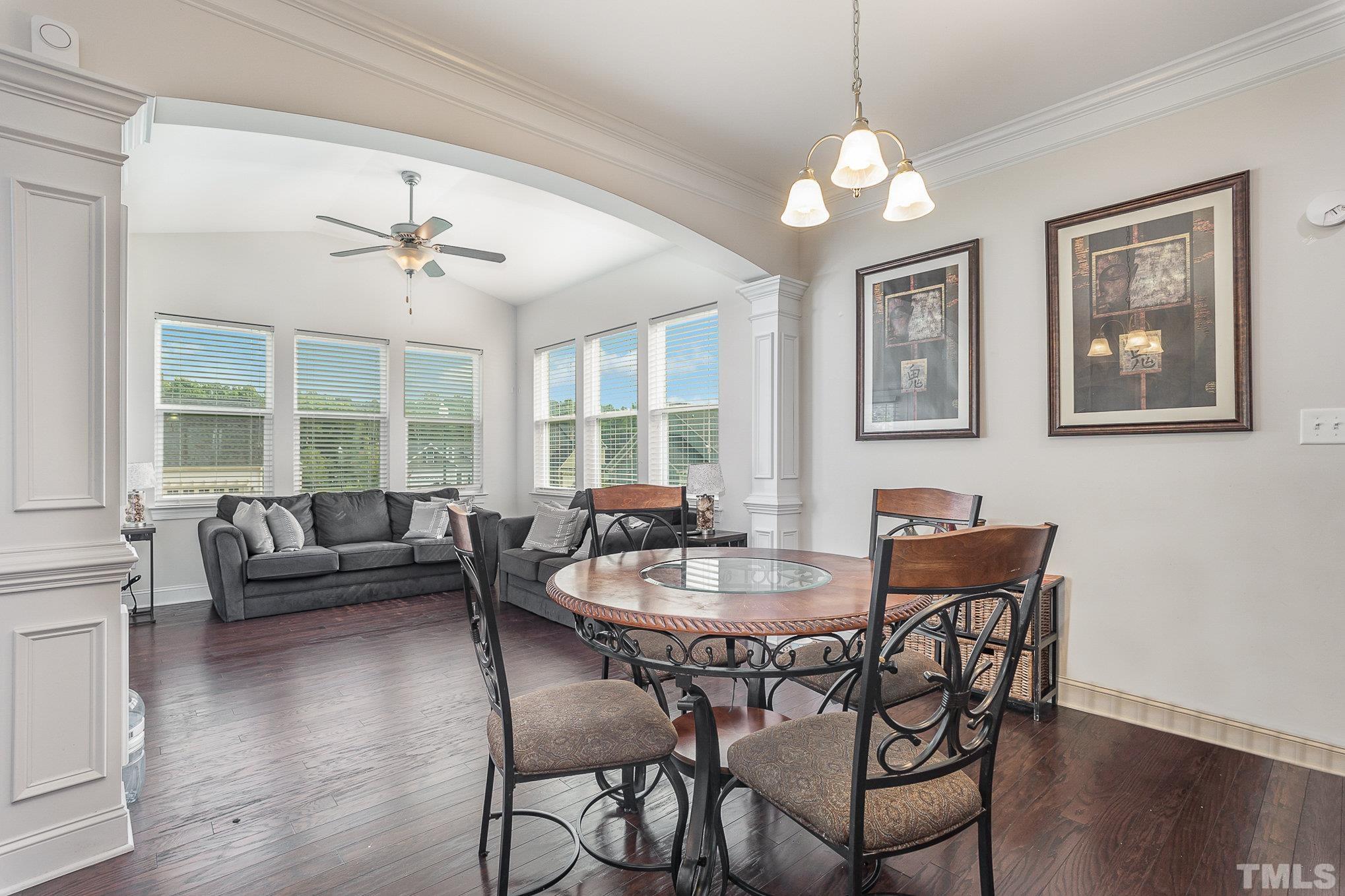 1513 Slate Ridge Road Knightdale, NC 27545 - Photo 8 of 36 a dining room with wooden floor a chandelier a wooden table and chairs