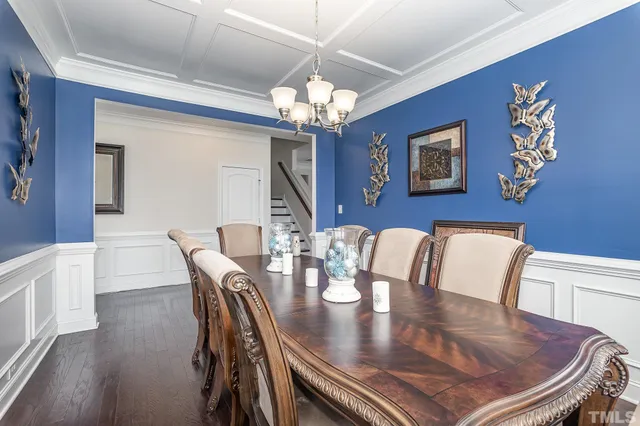 a view of a dining room with furniture a chandelier and wooden floor