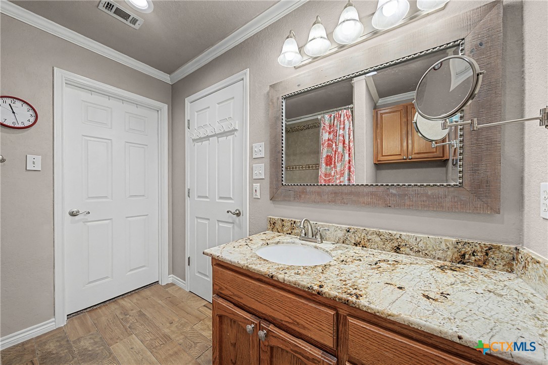 1601 Sunset Circle Cameron, TX 76520 - Photo 30 of 40 a bathroom with a granite countertop sink a mirror and a shower