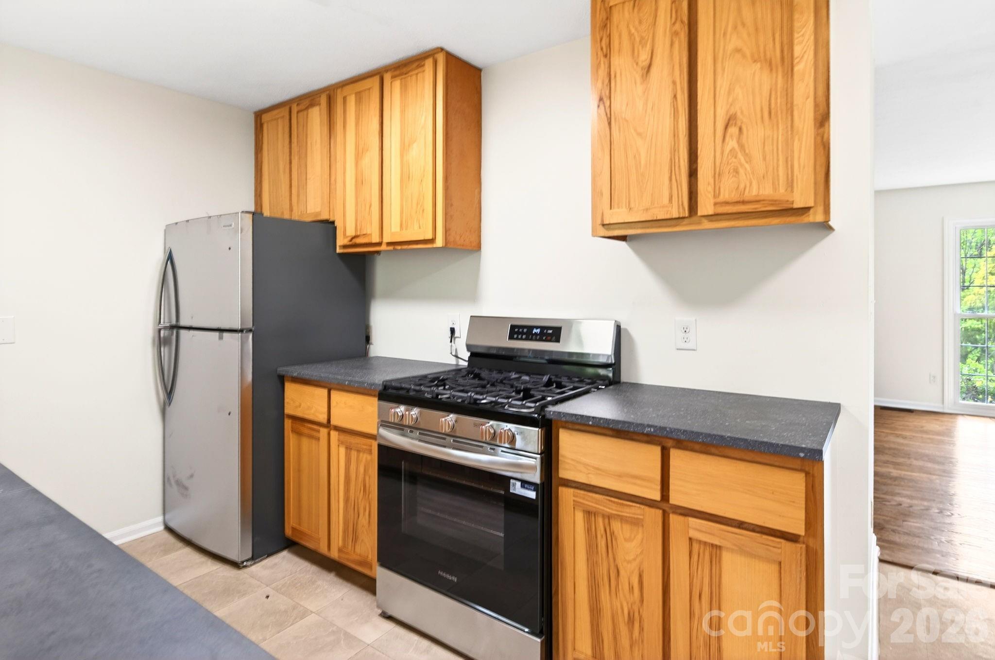 34 Wolfe Cove Road Asheville, NC 28804 - Photo 24 of 42 a kitchen with granite countertop wooden cabinets and a stove top oven