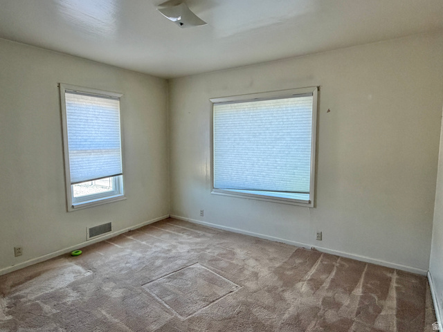 196 North 5th West Price, UT 84501 - Photo 13 of 27 Room featuring two windows with horizontal blinds, light-toned walls, and a ceiling-mounted light fixture