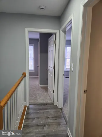 a view of a hallway with wooden floor and staircase