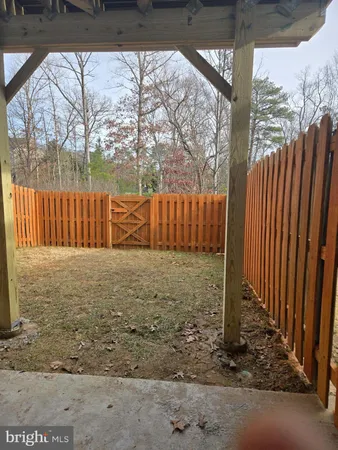 a view of a yard with wooden fence