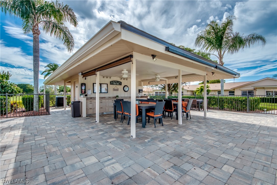 5585 Buring Court Fort Myers, FL 33919 - Photo 32 of 34 a view of a patio with a table and chairs under an umbrella