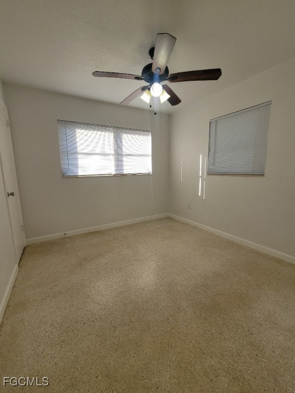 25 Maple Avenue North Lehigh Acres, FL 33936 - Photo 12 of 26 en empty room with windows and ceiling fan