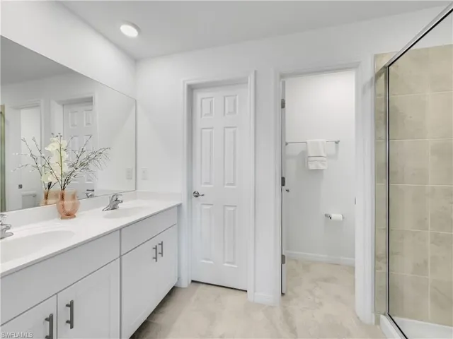 a spacious bathroom with a double vanity sink mirror and shower