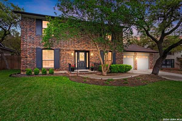 a view of a house with a yard and tree s