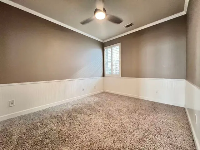 an empty room with a window and a ceiling fan