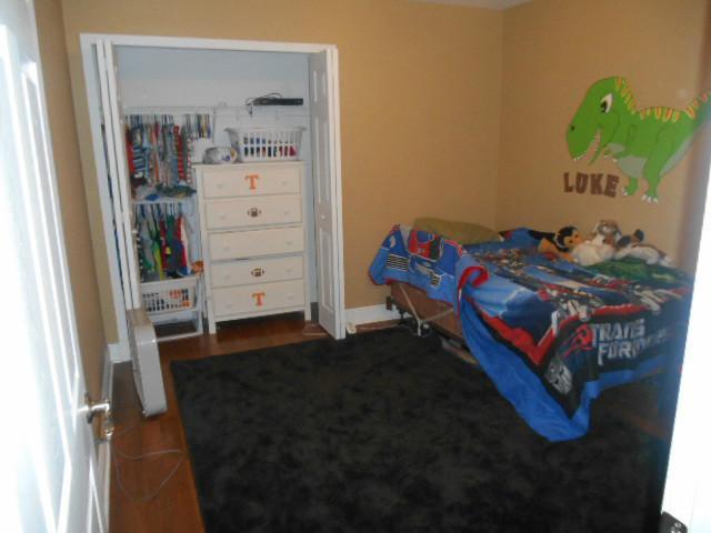 5780 Southeast Colee Avenue Stuart, FL 34997 - Photo 16 of 25 a bedroom with a bed and wooden floor