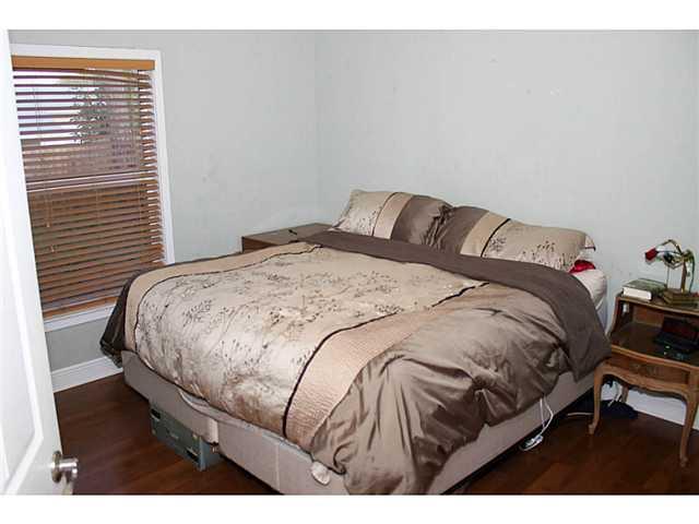 5780 Southeast Colee Avenue Stuart, FL 34997 - Photo 20 of 25 a bedroom with a bed and wooden floor
