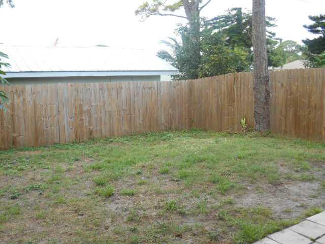 5780 Southeast Colee Avenue Stuart, FL 34997 - Photo 25 of 25 a view of a backyard with large trees and wooden fence