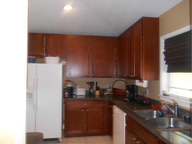 5780 Southeast Colee Avenue Stuart, FL 34997 - Photo 5 of 25 a kitchen with a sink a refrigerator and cabinets