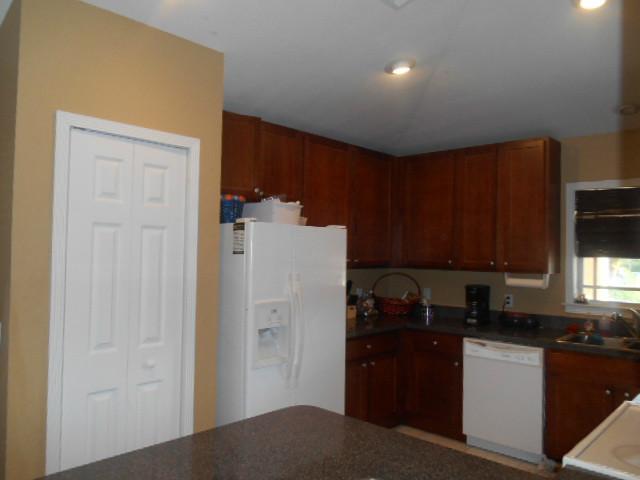 5780 Southeast Colee Avenue Stuart, FL 34997 - Photo 6 of 25 a kitchen with a refrigerator and cabinets