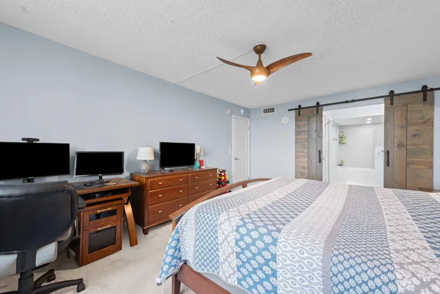 a bedroom with a bed and a computer on the desk