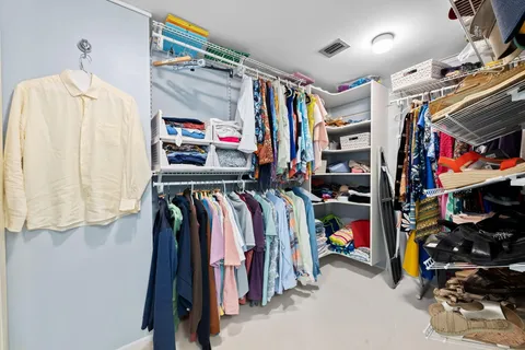 a view of walk in closet with clothes and shoes