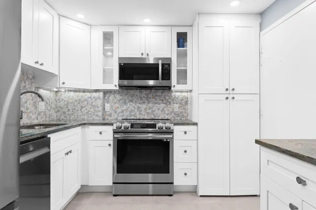 a kitchen with stainless steel appliances granite countertop a stove and a refrigerator