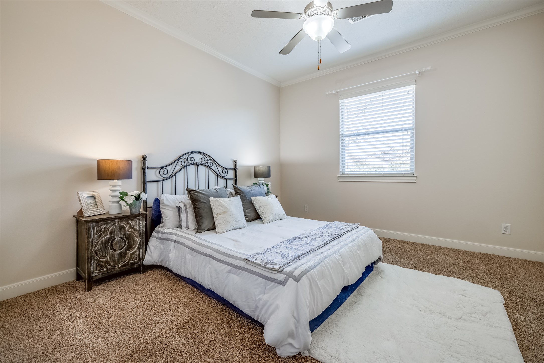 31102 Lower Oxbow Trace Fulshear, TX 77441 - Photo 28 of 50 a bedroom with a bed window and a chandelier