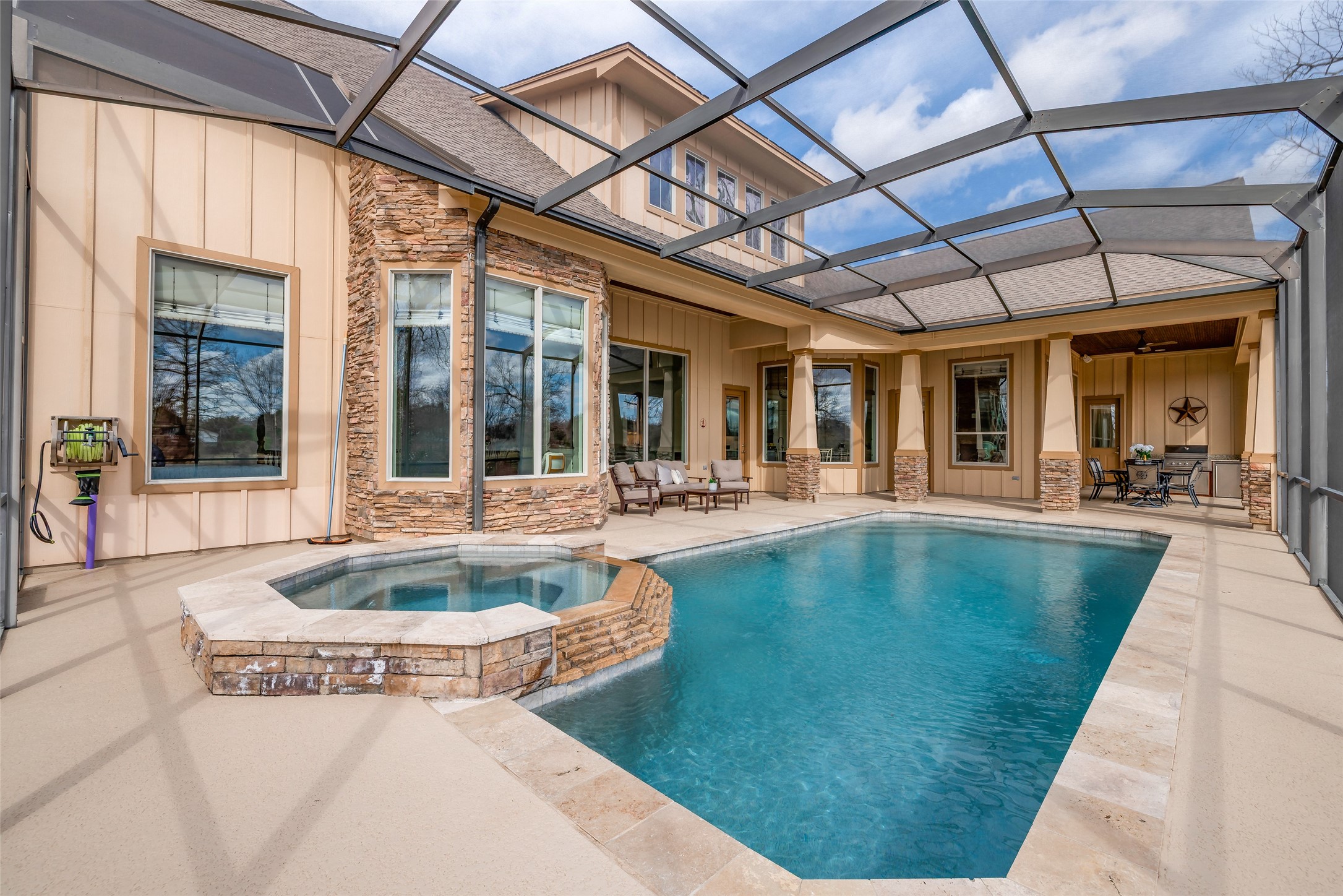 31102 Lower Oxbow Trace Fulshear, TX 77441 - Photo 3 of 50 Experience luxury outdoor living with a 30x13 ft heated pool & spa, all protected by insect netting. Enjoy the covered sitting area & outdoor kitchen on the patio.