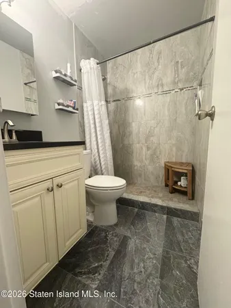 a bathroom with a sink a toilet and shower