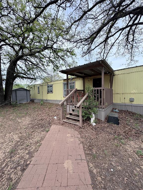6295 Rendon New Hope Road Fort Worth, TX 76140 - Photo 5 of 38 View of front of house featuring a wooden deck and a storage shed