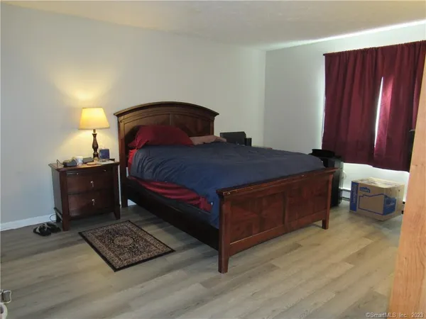 a bedroom with a bed dresser and a window