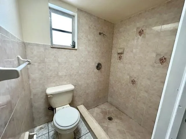 a view of a hallway with wooden floor and a bathroom