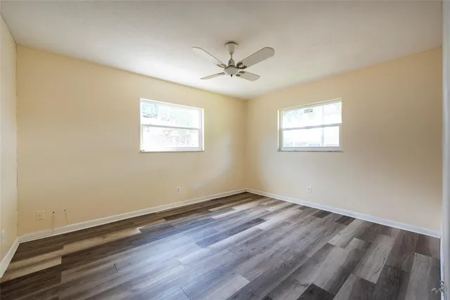 a bathroom with a toilet a sink a mirror a window and vanity