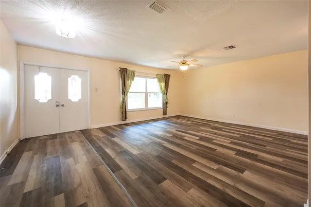 wooden floor in an empty room with a window