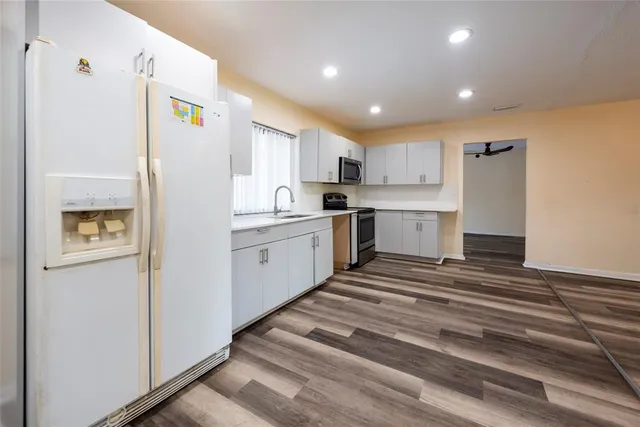 a view of a hallway with wooden floor and closet