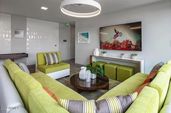 a living room with furniture kitchen view and a large window
