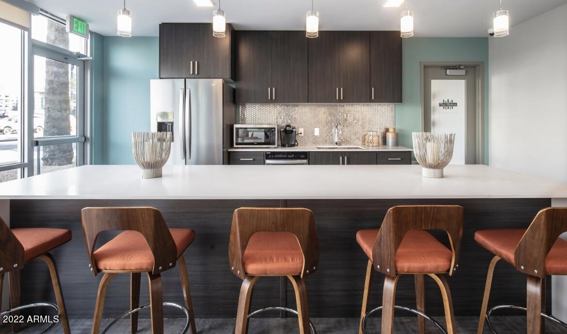 425 West Osborn Road, Unit 318 Phoenix, AZ 85013 - Photo 25 of 29 a kitchen with a dining table chairs cabinets and stainless steel appliances